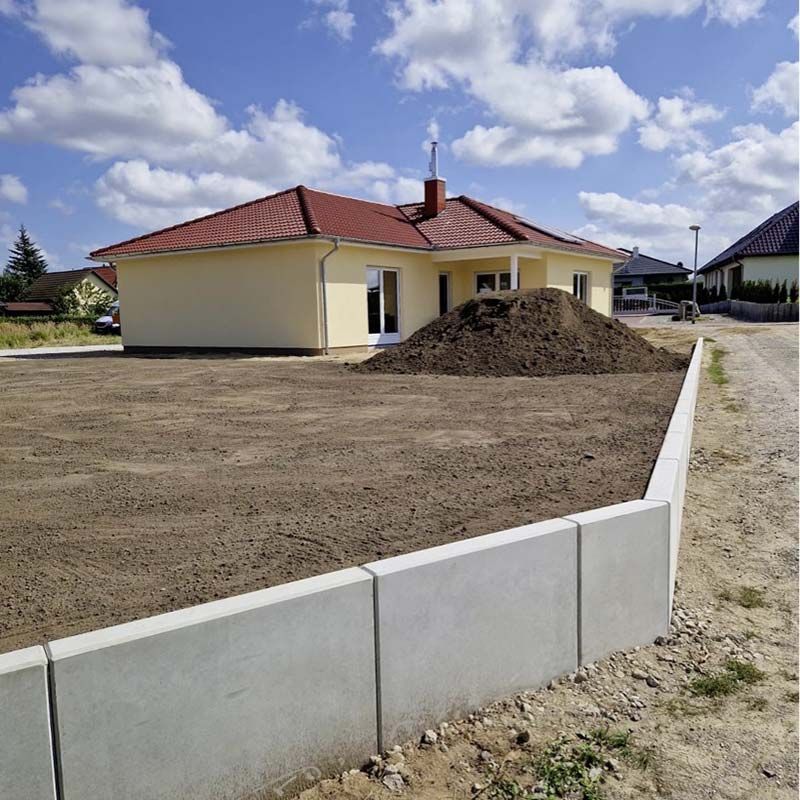 Grundstücksmodellierung zur Flächengewinnung und Wasserschutz durch Schaffung von Gefälle für ein Einfamilienhaus in Friedland.